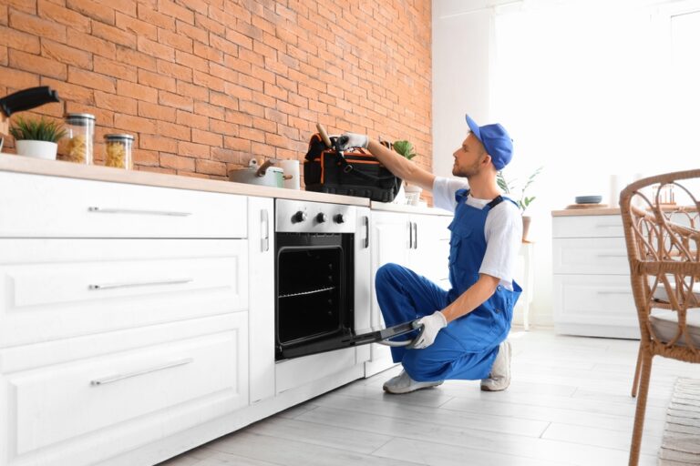 Male,Technician,With,Bag,Of,Tools,Repairing,Oven,In,Kitchen